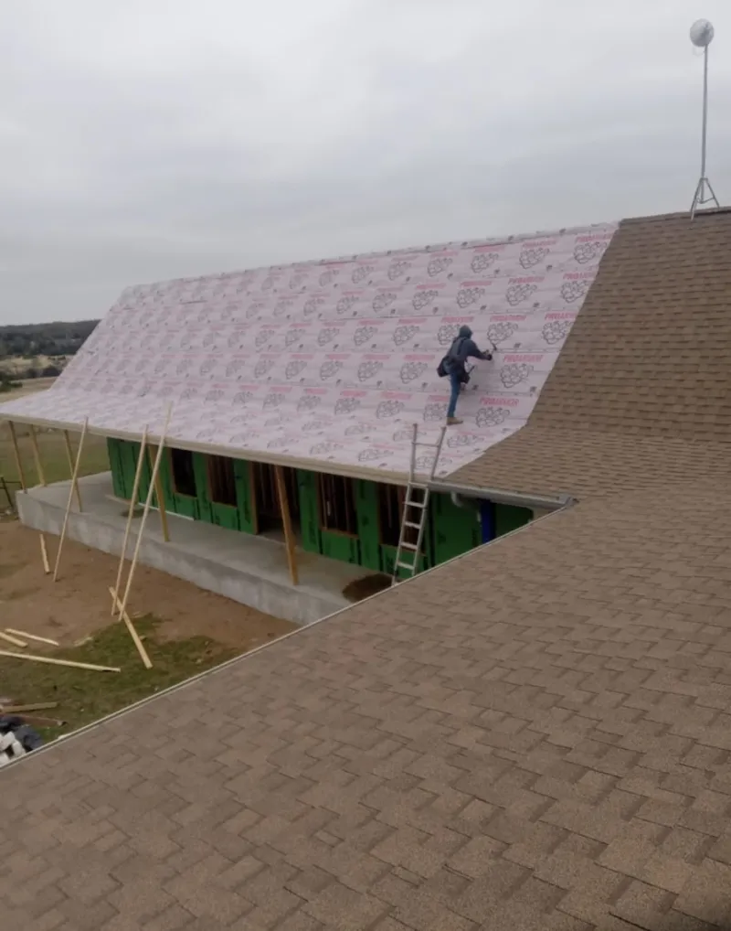 Worker preparing underlayment for a metal roof installation in Hollywood